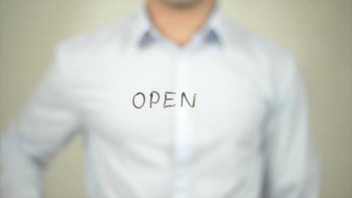Homme ouvert écrivant sur écran transparent