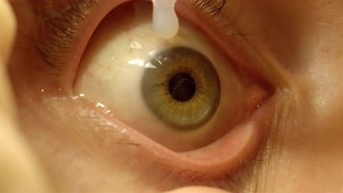 Close up of eye drop application on contact lens