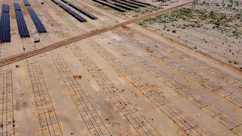 Vast aerial bird's eye view plus tilt-up of new solar panels and rack frames at Jambur solar farm
