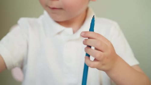 Young Child Opens Blue Marker At Home