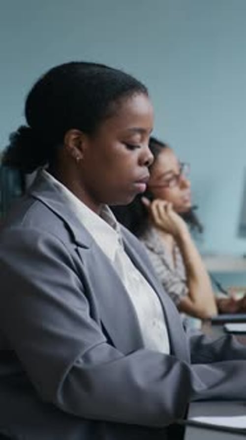 Ernsthafter Bediener tippt und schaut auf den Computerbildschirm gegen Kollegen