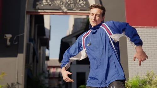 Man Dancing in Urban Setting on Sunny Day