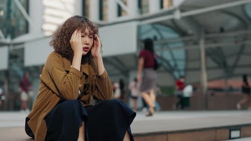 Woman Experiencing Headache in Urban Setting