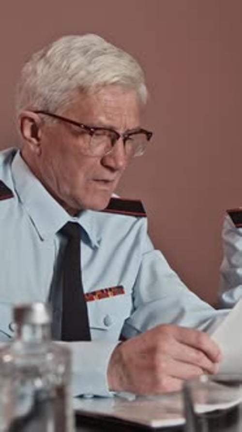 Serious Senior Police Officer Reviewing Documents