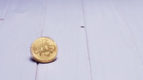 Bitcoin Spinning Slowly on Light Wood Surface
