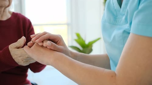 Healthcare Worker Holding Hands with Senior Patient