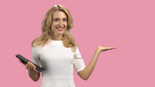 Portrait of a Mature Happy Caucasian Woman Holding a Tablet Device and Showing Copy Space