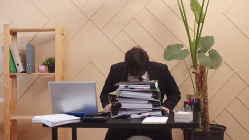 Stressed Business Man With Stack of Paperwork
