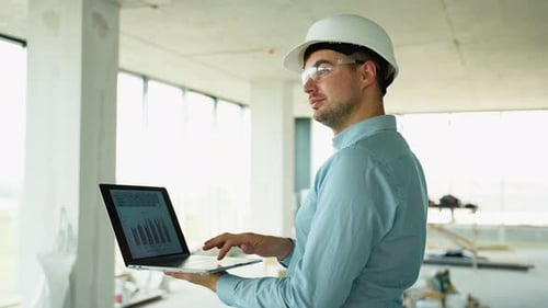 Engineer Using Laptop for Progress Tracking Onsite