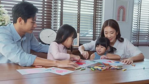 Asian family with children Drawing and painting on table