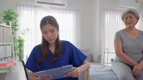 Asian beautiful caregiver examine senior woman patient at nursing home.