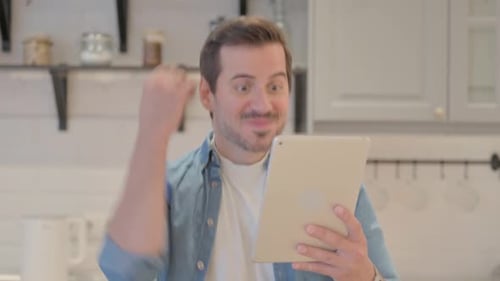 Man Celebrates Tablet Success in Kitchen