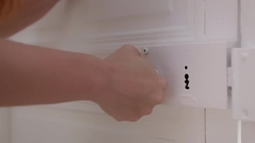 Redhead woman trying to open door with old rusty knob, close up