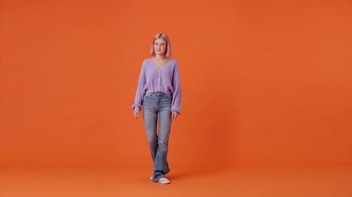 Woman Showing Sign of Dislike on Orange Studio Background