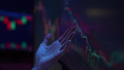 Hand Gesturing Towards Stock Chart Displayed on Screen