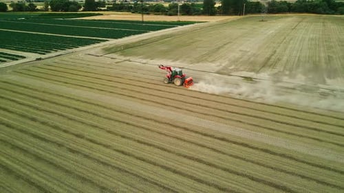 Tractor Working in a Field Surrounded by Farmlands - Aerial View