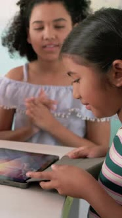 Vertical video: Turning tablet folio, girl in green top showing turbine models in class, copy space