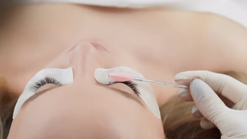 Veja uma esteticista aplicando extensões de cílios com precisão e higiene em um spa ou salão de beleza