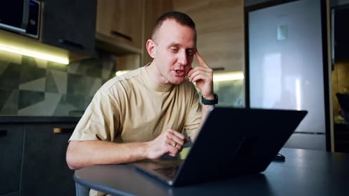 Man Working on Laptop in Modern Kitchen