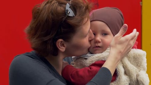 Woman Kisses Child in loving Close Up Shot