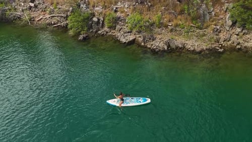 Aerial View Exploring Nature on a Paddleboard Through a Green Canyon