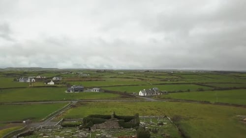 Flying over Irish ruins and rolling green countryside on grey day
4K 29fps