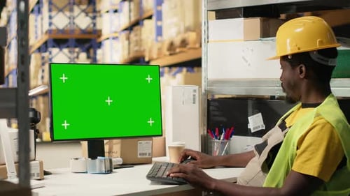 Empleado de depósito afroamericano que gestiona el flujo de trabajo con Chroma Key Screen