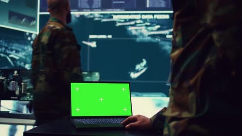 Military Personnel Monitoring Green Screen in Control Room