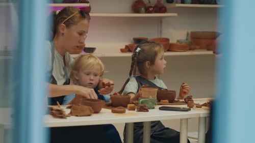 Mother with Kids Learn Pottery and Shape the Clay in the Pottery Studio During Pottery Masterclass