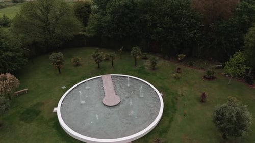 Aerial view of round fountain garden with lush greenery