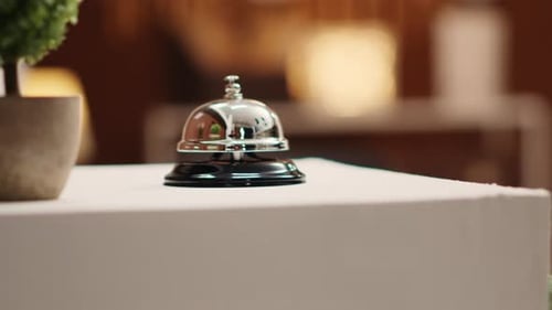 Shiny Silver Service Bell on a White Table