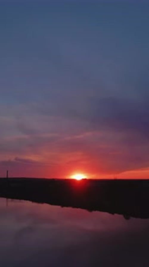 Vibrant sunset reflecting in river water at dusk