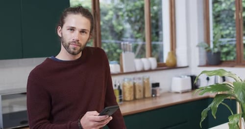 Man Using Smartphone in Modern Kitchen