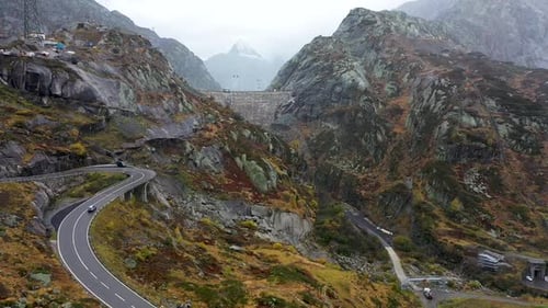 View on Grimselpass high mountian alpine road , cars, dam and Swiss Alps in background, Switzerland.
