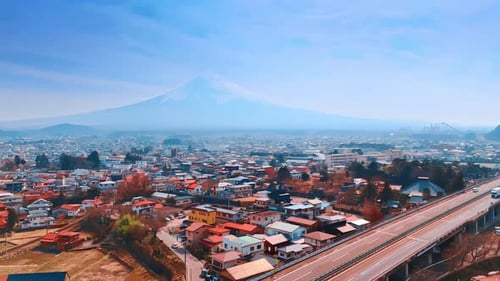 Cars go by the freeway crossing the cityscape of Tokyo. Magnificent Mount Fuji