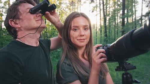 Observation des
oiseaux dans le parc. Portrait d'ornithologues avec jumelles et appareil photo avec téléobjectif. Amate