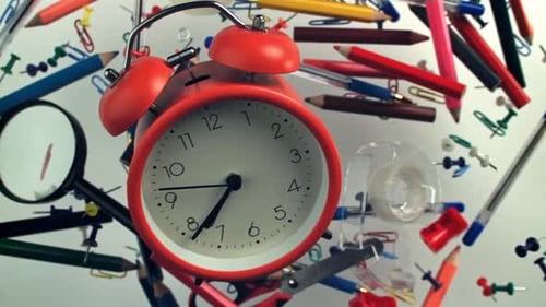 An Alarm Clock with Various School Supplies Flies Up and Falls Filmed on a Highspeed Camera at 1000