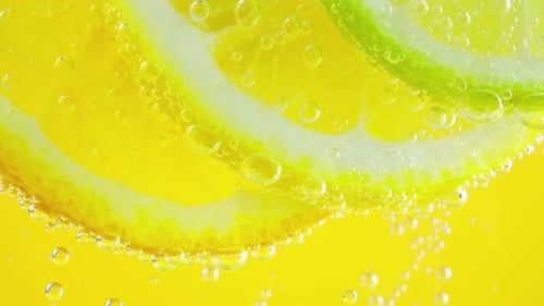 Bubbles rising around citrus fruit underwater