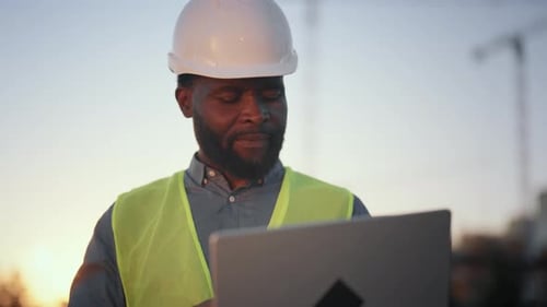 Mittleres Porträt eines hochqualifizierten Ingenieurs mit Laptop auf der Baustelle Innovation und Moderne