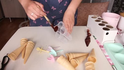 A Woman Smears Liquid Chocolate On A Plastic Ice Cream Mold. Makes Frosting For Homemade Ice Cream.