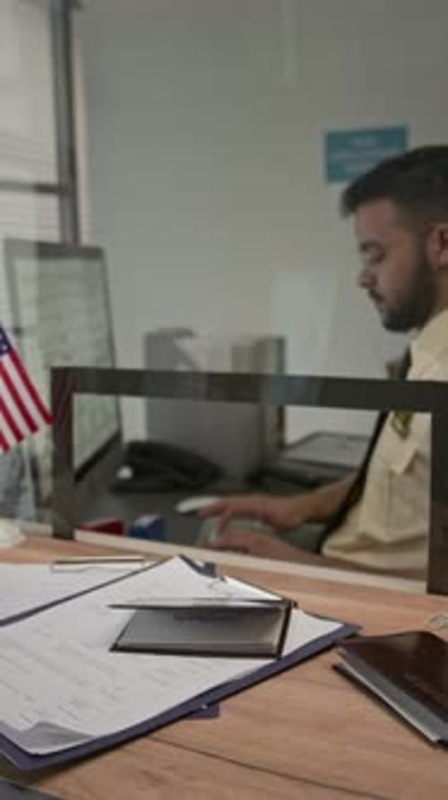 Man Works at Desk With Passport and Documents