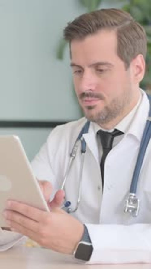 Male Doctor using Tablet in Clinic, vertical video