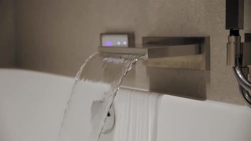 Waterfall Faucet Filling Up Modern Bathtub