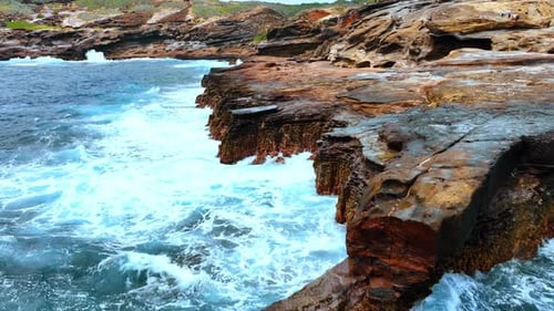 Ocean Waves Crashing on Rocky Coastline Aerial View