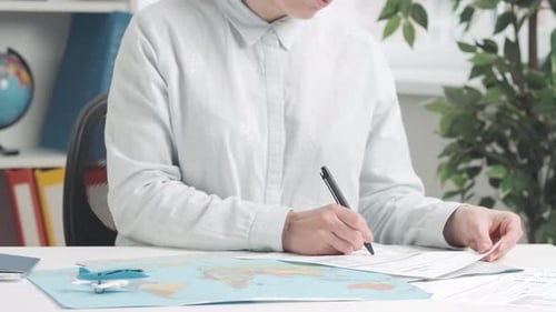 Woman Completing Paperwork for Travel Plans