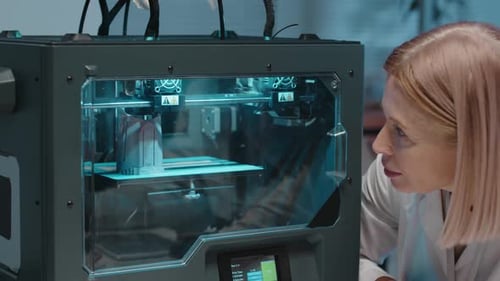Un ingénieur attend une imprimante 3D pour terminer un nouveau prototype