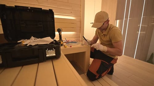 Man Working on Electrical Wiring in Brightly Lit Room
