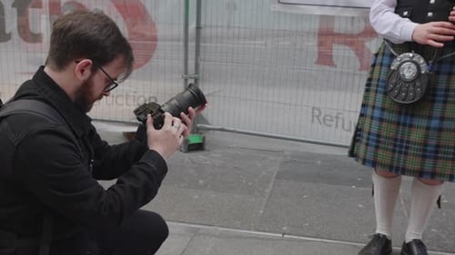 Photographer Takes Picture of Bagpiper on City Street