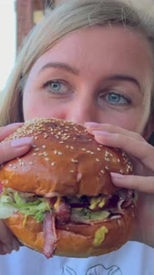 A Hungry Woman Eats a Big Burger Street Food Junk Food Hot Dog Burger Hamburger Vertical Video