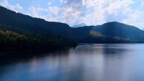 Calm lake below mountain shadows. Peaceful lake reflecting mountain ridges